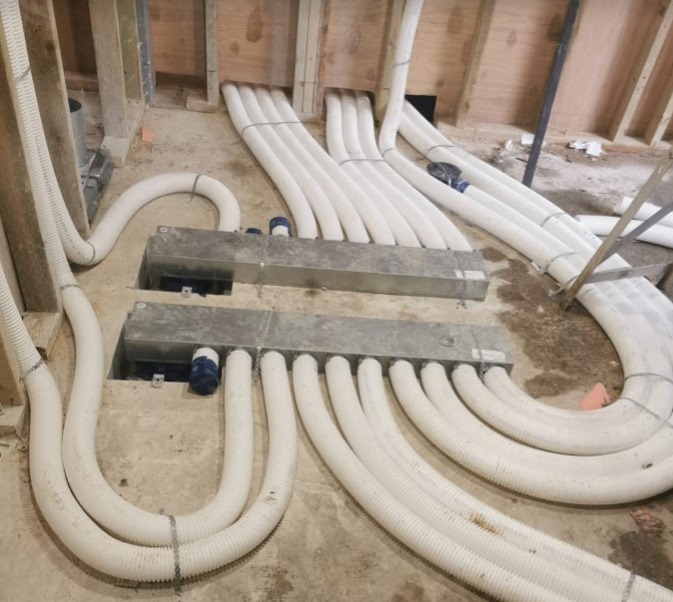 Manifolds for a radial semi-rigid ductwork system mounted on concrete floor