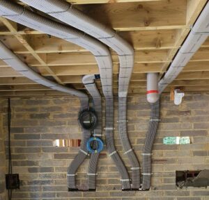 Flat 51mm ducting pinned to wall and rising into ceiling area