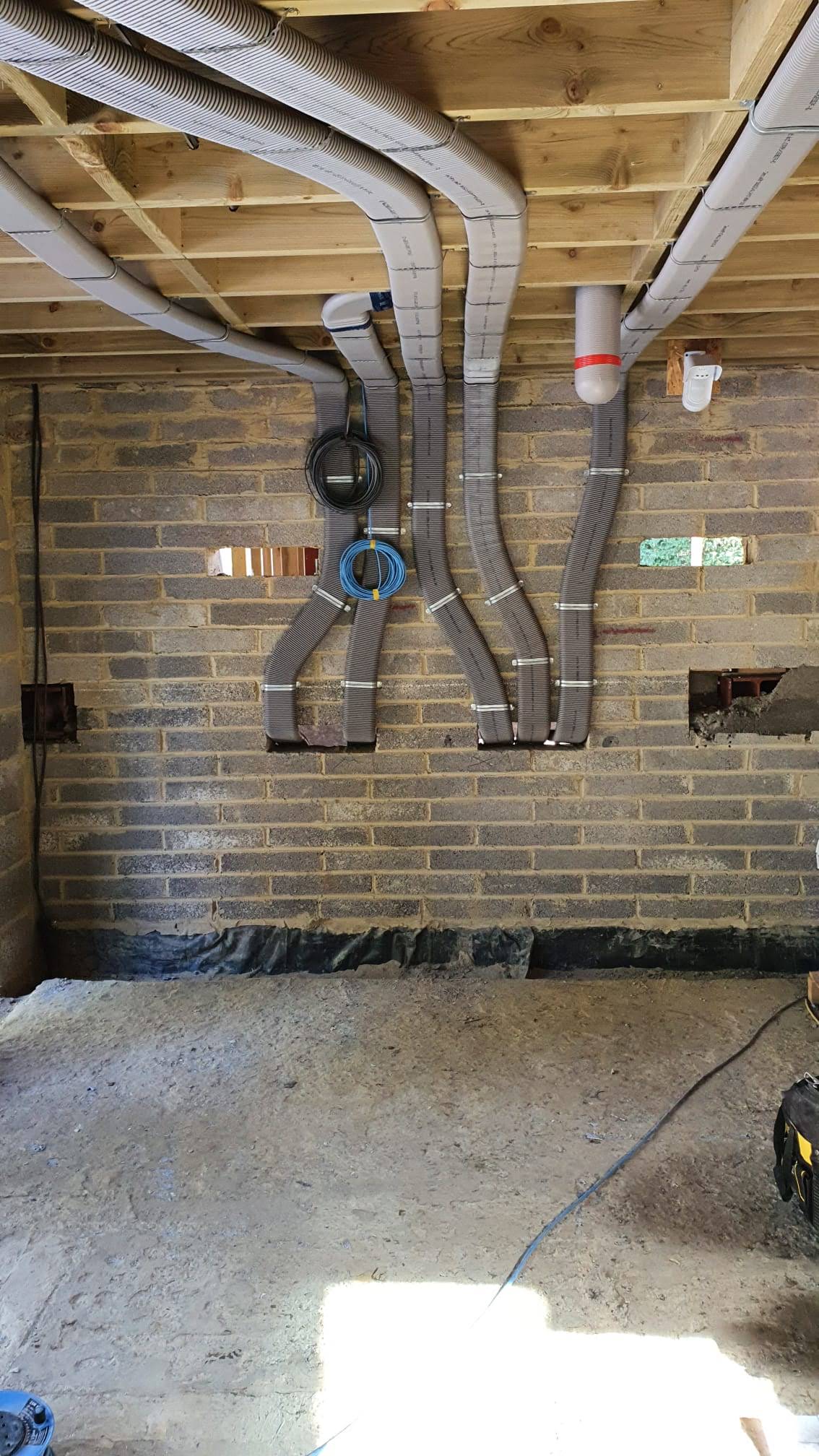 Flat 51mm ducting pinned to wall and rising into ceiling area