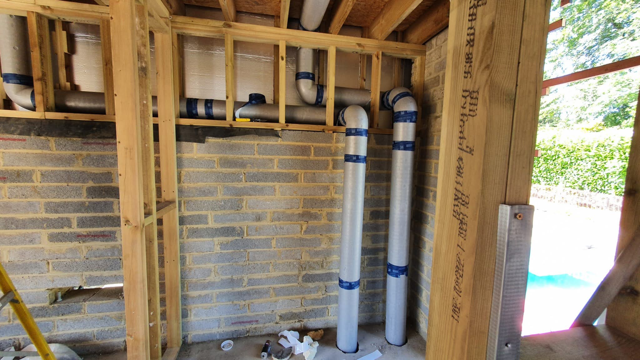 Preinsulated ducting running from basement to roof behind fitted wardrobe frame