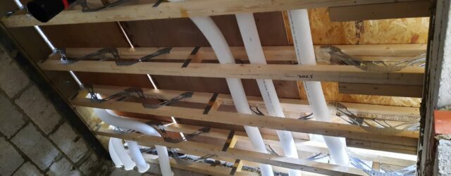 90mm semi-rigid ducting in webbed joists and passing through core-drilled blockwork wall for MVHR system