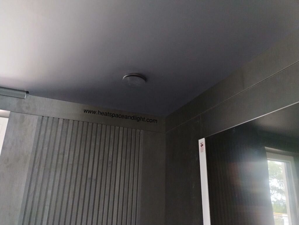 Black MVHR supply valve on black ceiling to hide it in cinema